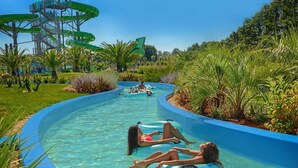 A water park with a long, winding water slide surrounded by lush greenery. - Beach House IVE –Romantic escape with jacuzzi, pool & olive grove charm in Pomer (Pomer)