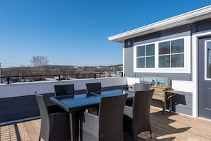 Eine Terrasse mit Tisch, Stühlen und einer Holzbank, mit Blick auf die Umgebung.