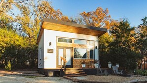 A modern, single-story building with a wooden roof and large windows. - The Maple Casita at Selah Place (Athens)