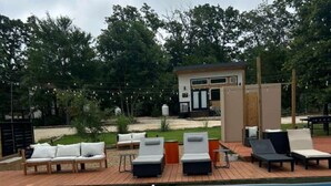 A swimming pool with lounge chairs and a small building in the background. - The Maple Casita at Selah Place (Athens)