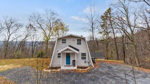 A single-story house with a gabled roof, a front porch, and a blue door. - The Overlook (Winchester)