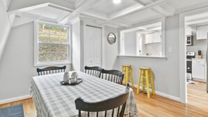 A dining area with a checkered tablecloth, wooden chairs, and a yellow stool. - The Overlook (Winchester)