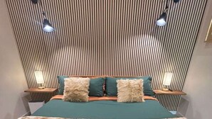 A bed with a fur-like cover, wooden headboard, and bedside lamps. - The Walnut Villa at Selah Place (Athens)