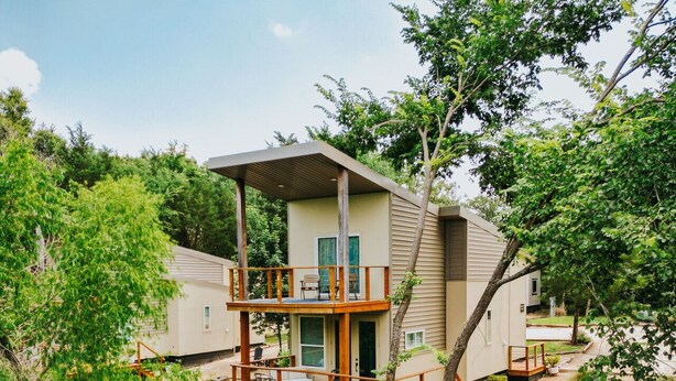 A two-story house with a deck overlooking a body of water. - The Walnut Villa at Selah Place (Athens)