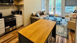 A modern kitchen with a wooden bar counter, stainless steel appliances, and a ceiling fan. - Villa 1 · Waterfront Villa, spacious with 2 balcony and beds (Athens)