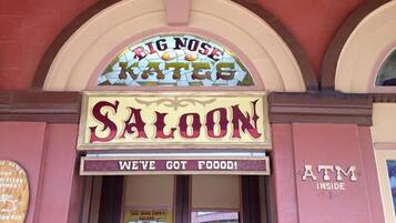 A saloon with a sign reading "BIG NOSE KATES SALOON" and "WE'VE GOT FOOD!"