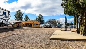 A campground with RVs, a picnic table, and a building labeled 'Cactus Stop'.
