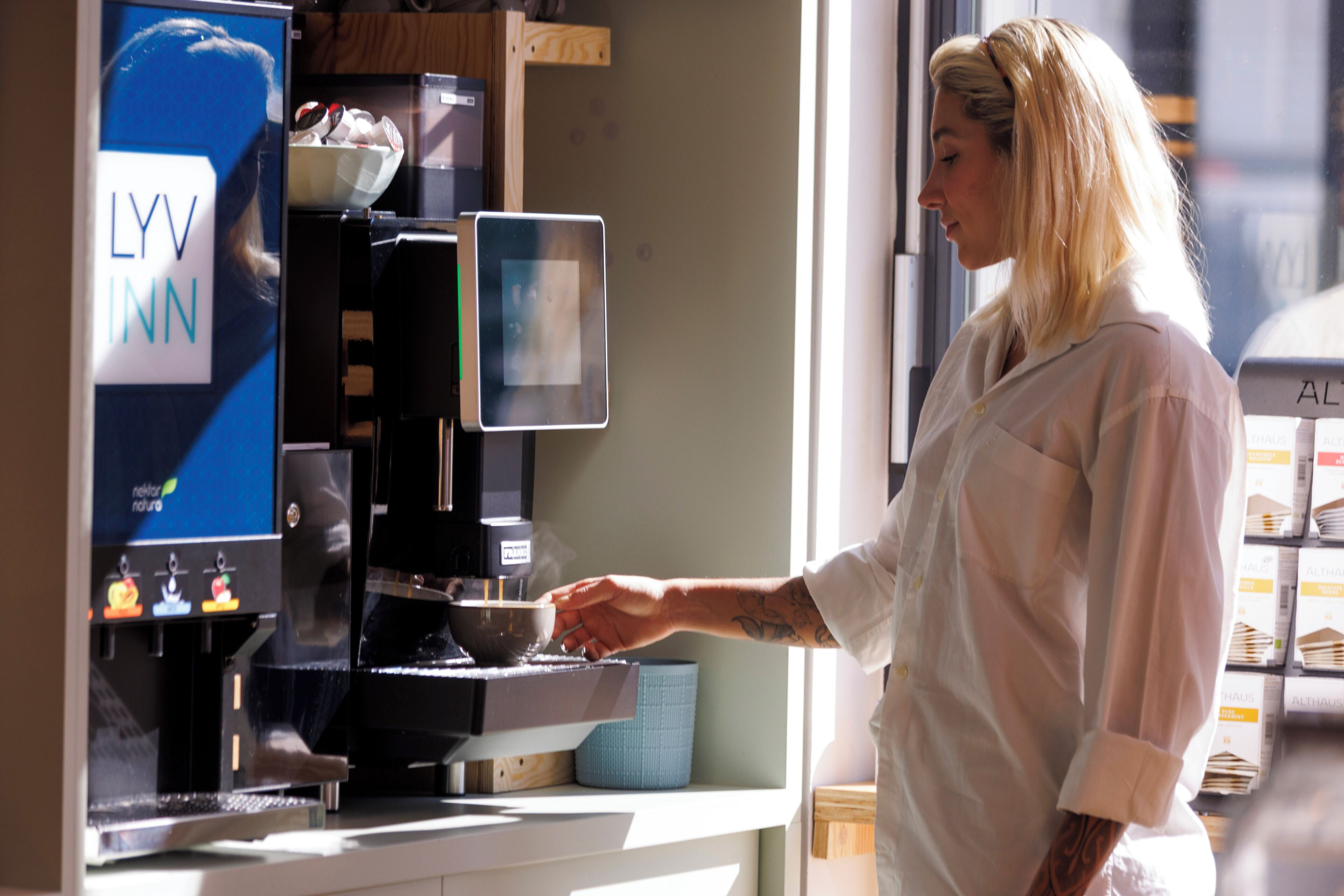 Eine Kaffeemaschine mit digitalem Display, eine Schüssel und eine Tasse.