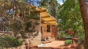 A rustic stone building with a covered porch and a small garden area. - Welcome to The Gem-Best Location in Uptown Sedona (Sedona)