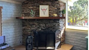 A stone fireplace with a mantel shelf, a framed picture, and a small statue. - Welcome to The Gem-Best Location in Uptown Sedona (Sedona)