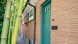 A brick building with a green door and a window.