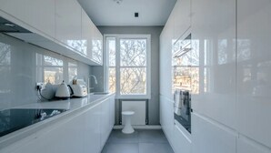 Een moderne keuken met witte kastjes, een zwart aanrecht en een raam dat voor natuurlijk licht zorgt.