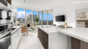 A modern kitchen with a large island, built-in appliances, and a view of the city.