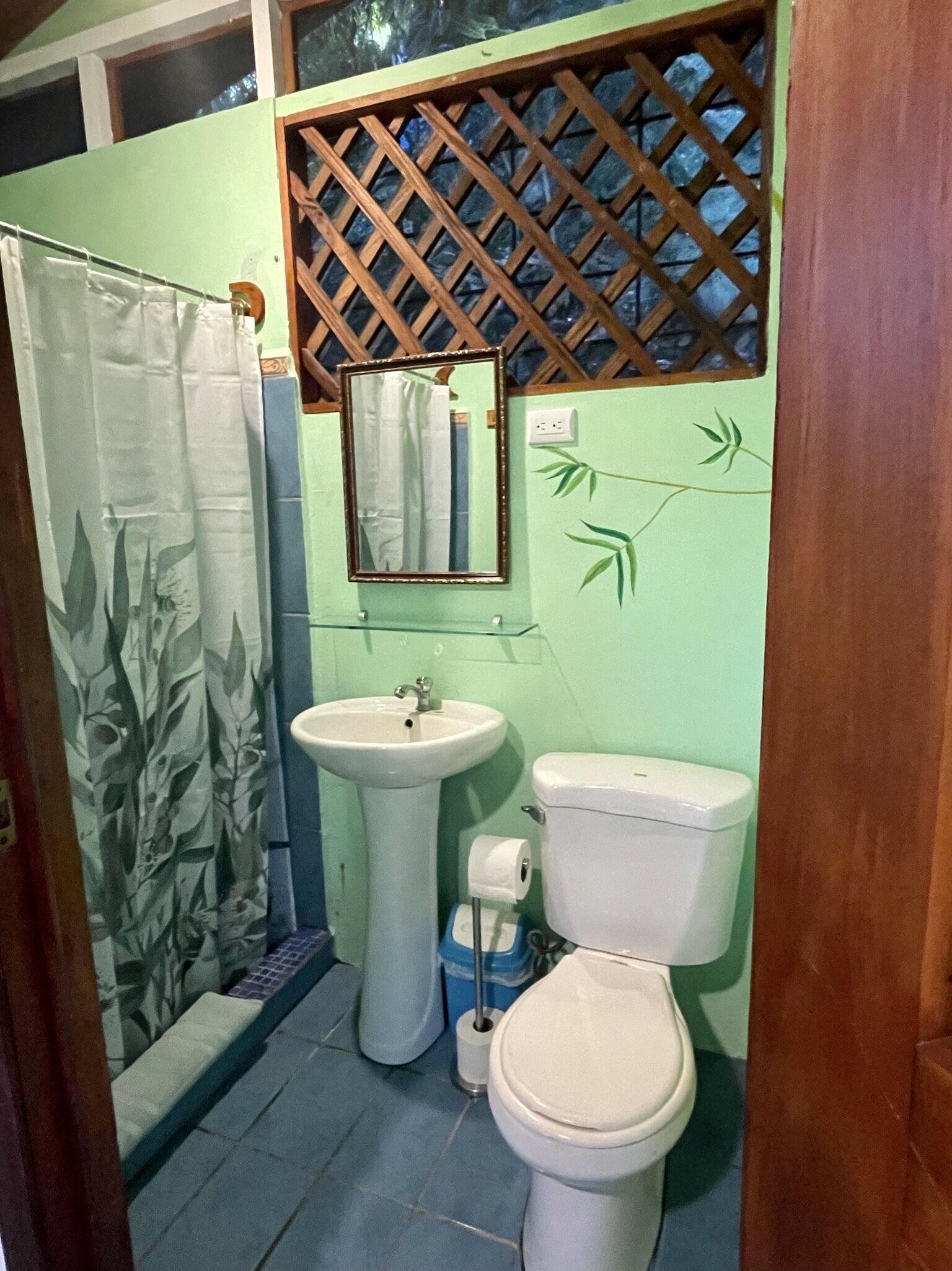 A bathroom with a sink, toilet, and a mirror.