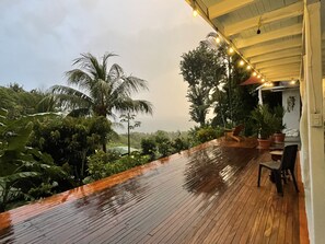 A wooden deck with potted plants and outdoor seating. - The Chorotega Arte y Sol Hotel (Cóbano)
