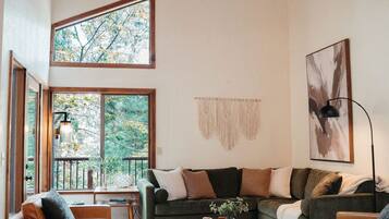 Vaulted great room with walls of windows, a big sectional and seating for the whole group