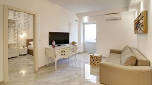 A modern living room with a flat-screen TV, a beige sofa, and a decorative wooden wall piece. - Villa Vanda - Deluxe Two Bedroom Apartment with Swimming Pool (Dubrovnik)