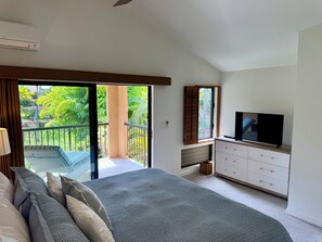 A bedroom with a large bed, a TV, a dresser, and a balcony with a view of greenery. - Luxury 1 Bed 2 Bath Direct Ocean Front Property - 5 Star -  Sleeps 4 - Sleeps 4 (Kihei)