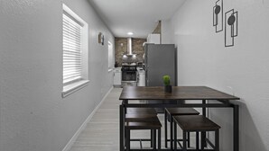Un pasillo estrecho que conduce a una cocina con comedor.