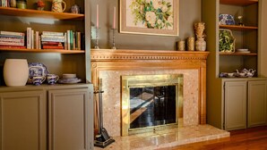 A fireplace with a mantel, bookshelves, and decorative items.