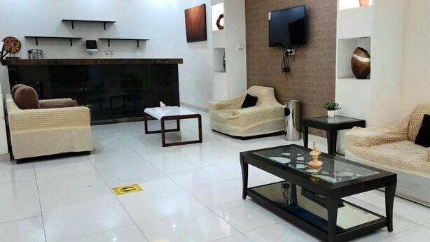 A modern living room with a fireplace, sofas, a coffee table, and a TV mounted on the wall.