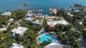 An aerial view of a coastal resort with a swimming pool, multiple buildings, and boats in the marina. - Marathon Key Beach Club 2 bedroom Condo D102-C101 (Marathon)