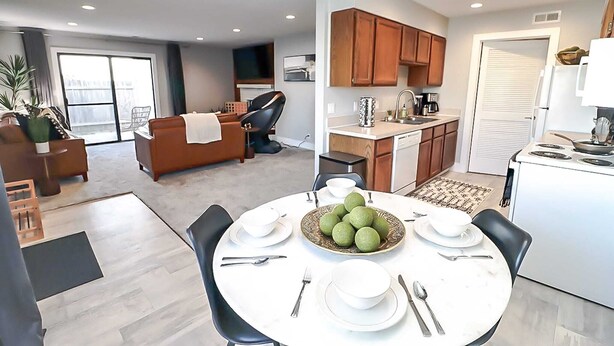 Un appartement moderne comprenant un coin repas, une cuisine et un espace de vie.
