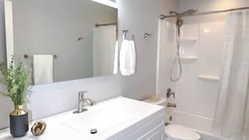 Bathtub, hair dryer, towels, shampoo