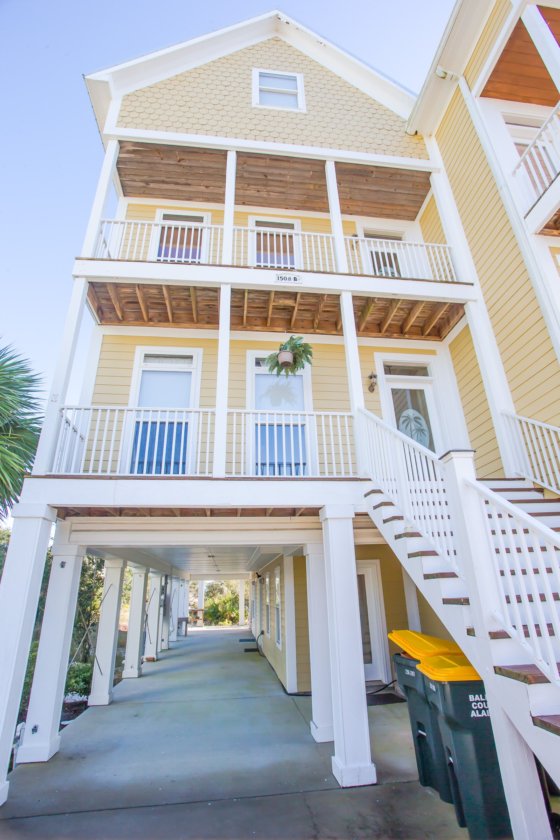 A multi-story building with a covered walkway and a staircase leading to the upper floors.