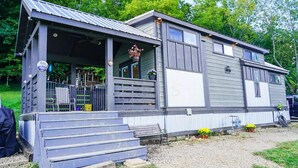 Ein Wohnmobil mit Veranda, Treppen und einer kleinen Terrassenfläche.