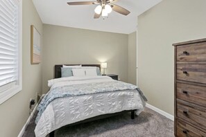 Cozy retreat with a single bed, dresser, and ceiling fan.