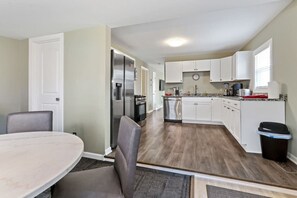 Enjoy cooking in this well-equipped kitchen with a refrigerator, oven, and microwave, and dine at the adjacent round table.