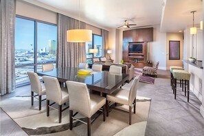 Enjoy a panoramic city view from the comfort of this stylish room, featuring a dining table, sofa, and flat-screen TV.
