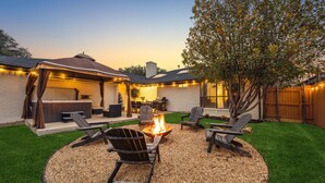 A backyard with a fire pit, outdoor seating, and a covered patio area. - Zen Back Yard with Hot Tub & Firepit: Spa at Home (Dallas)