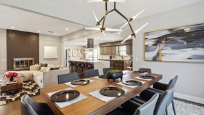 A modern dining area with a wooden table set for six, surrounded by chairs. - Zen Back Yard with Hot Tub & Firepit: Spa at Home (Dallas)