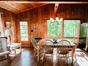 Dining table with lake and forest views. Table leaf and extra chairs available - Beachfront Cottage on Little Traverse Lake (Cedar)