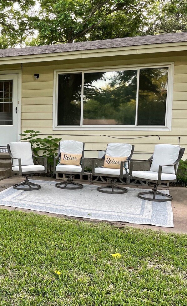 A house with a covered patio area featuring four chairs with 'Relax' pillows. - *New* Updated House - Walk to Hospital, 3 Beds (Temple)