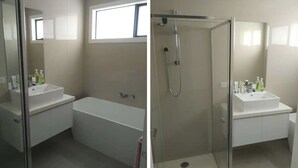 Et moderne badeværelse med badekar, bruser og håndvask.