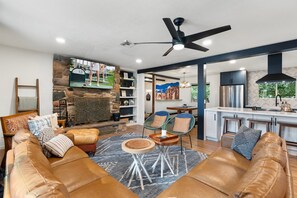 Relax in this inviting space with a leather sofa, stone fireplace, and functional kitchen area.