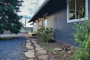 Stroll up the stone pathway to the front door, flanked by a small tree and bush, and enter this charming home.