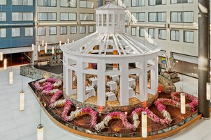 Un patio central con un pabellón, rodeado de mesas y sillas, y un arreglo floral.