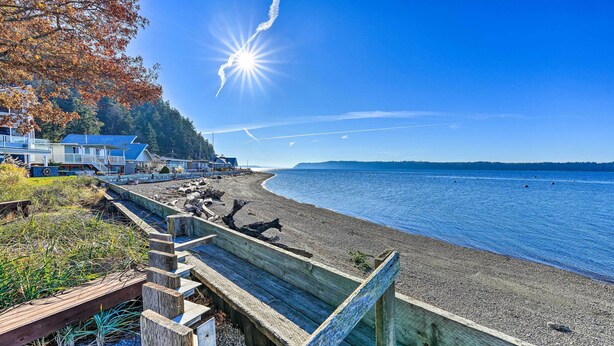 A wooden boardwalk leading to a beach with houses in the background. - McKees Beach House w/ Ocean Views, Hot Tub! (Stanwood)