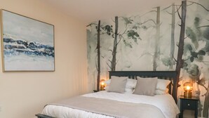 A bedroom with a bed, nightstands, and a wall mural. - Garden Cottage (Alnwick)