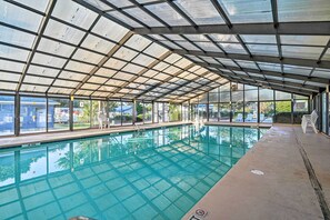 An indoor swimming pool with a glass ceiling, clear pool water, and a view of the outside. - Walk to Ocean: Lovely Myrtle Beach Getaway! (Myrtle Beach)