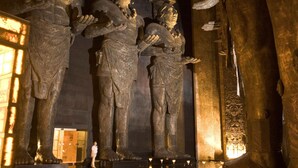 A large, ancient stone statue with intricate carvings and a figure holding a bowl. - Grand Mayan (Playa del Carmen)