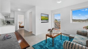 Een moderne woonkamer met keuken, eethoek en slaapkamer.