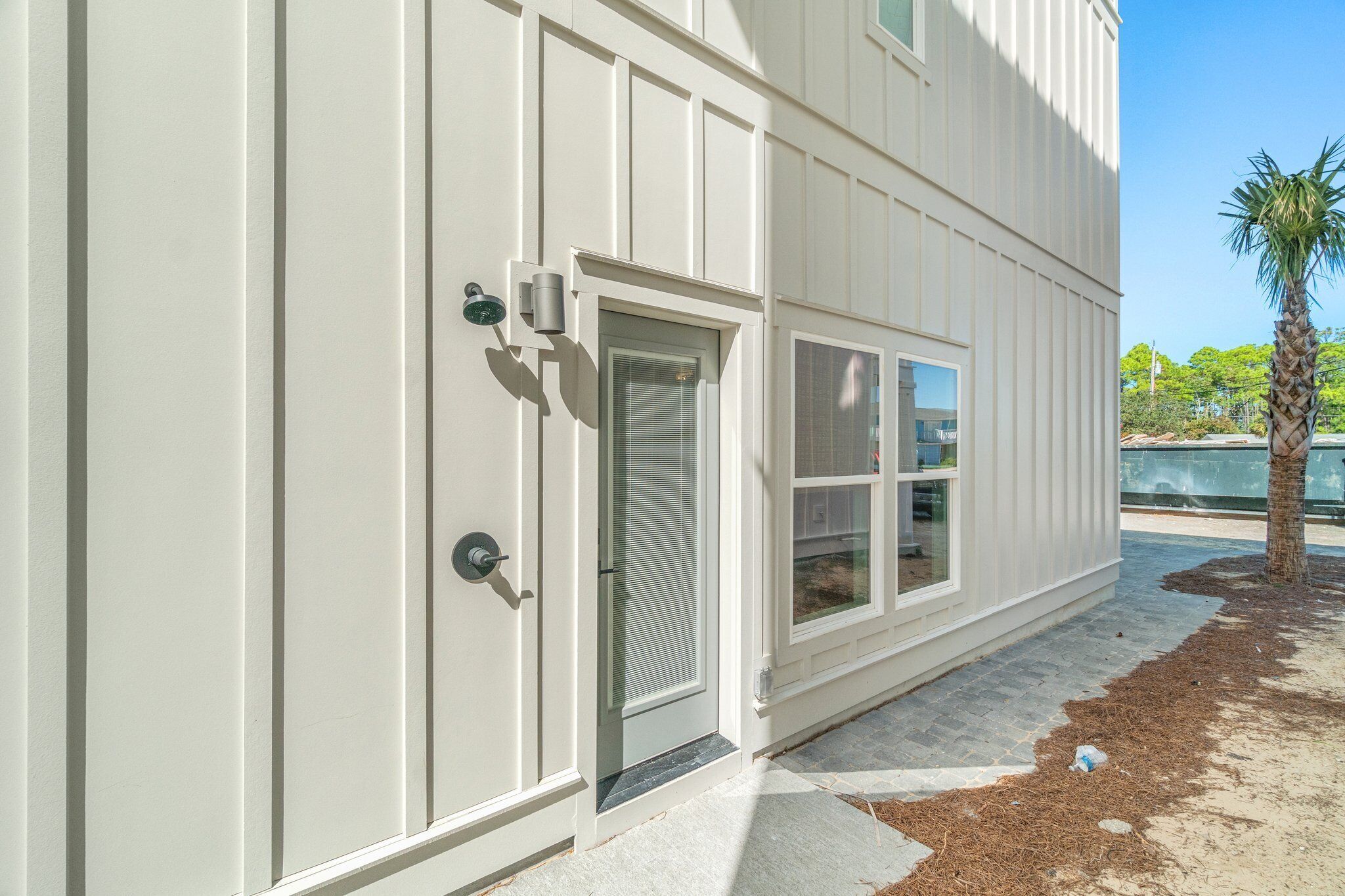 A modern building with a white exterior, a door with a glass panel, and a window.