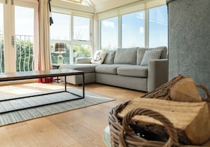 A modern living room with a sectional sofa, a coffee table, and a large window.