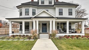Een twee verdiepingen tellend huis met een overdekte veranda, een symmetrische gevel en een centrale ingang.
