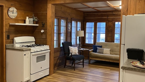 A cozy cabin-style kitchen with wooden walls and a dining area.